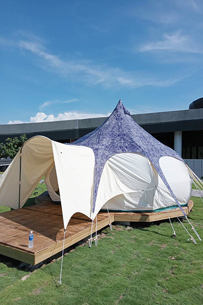 露營場帳篷外觀採藍、紫與白色風格呼應高美濕地藍天海景。
