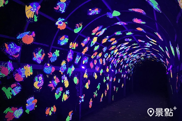 綠蔭隧道內滿佈螢光果實造型的〈實光旅行〉作品。